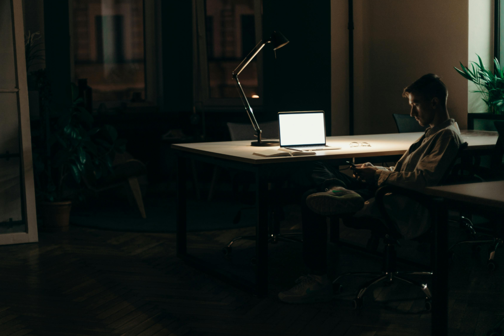Man sitting at desk distracted on his phone